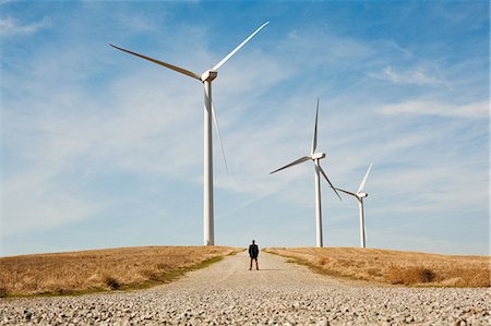 Vue éloignée de l'homme en face de turbines éoliennes Photographie de stock - Premium Libres de Droits, Code: 614-05650973