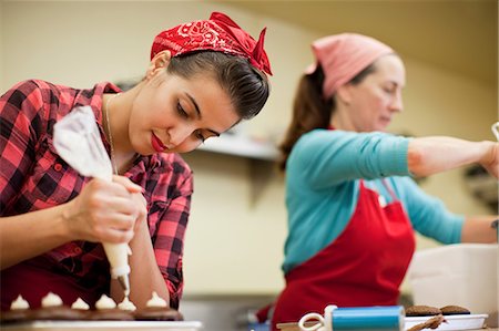 patisserie interior - Young woman using icing bag in bakery Stock Photo - Premium Royalty-Free, Code: 614-05662182