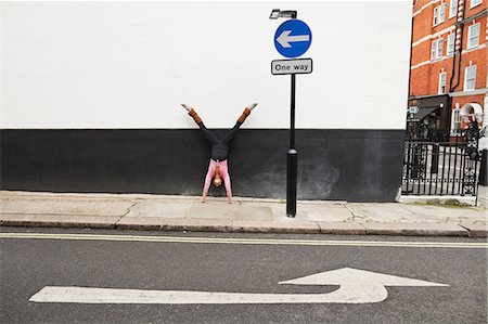 road sign - Woman performing handstand on pavement Stock Photo - Premium Royalty-Free, Code: 614-05662209
