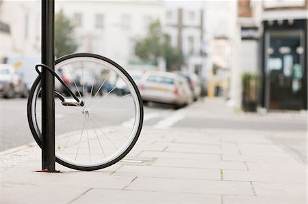 proteger - Single bicycle wheel secured to lamp post Foto de stock - Royalty Free Premium, Número: 614-05662311