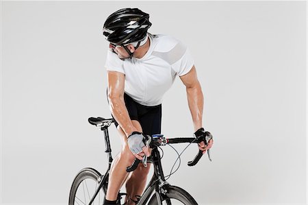 simsearch:614-05792261,k - Male cyclist looking over shoulder Foto de stock - Royalty Free Premium, Número: 614-05792259