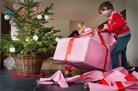 rip paper - Two boys unwrapping Christmas presents Foto de stock - Sin royalties Premium, Código: 614-05792385