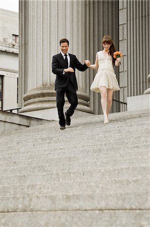 excited couple celebrate - Newlywed couple descending steps together Stock Photo - Premium Royalty-Free, Code: 614-05792400