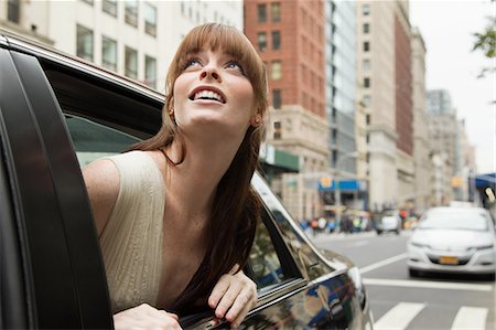 fringe - Young woman leaning out of taxicab window, looking up Stock Photo - Premium Royalty-Free, Code: 614-05792432