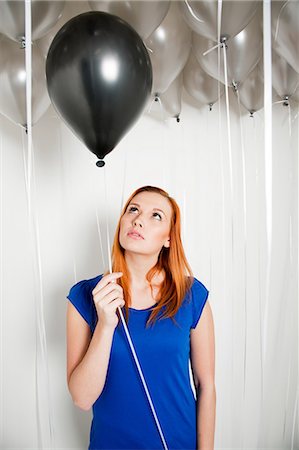 party woman studio - Young woman holding a black balloon Stock Photo - Premium Royalty-Free, Code: 614-05792506