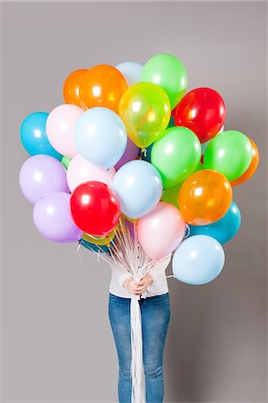 Woman holding large amount of balloons Stock Photo - Premium Royalty-Free, Code: 614-05792513