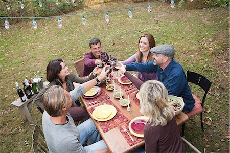 dinner party sit down - Friends toasting glasses at outdoor dinner Stock Photo - Premium Royalty-Free, Code: 614-05792556