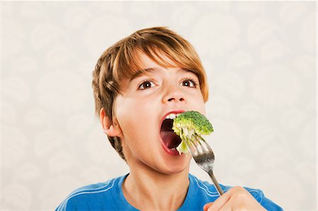 Boy eating broccoli Foto de stock - Sin royalties Premium, Código: 614-05818908
