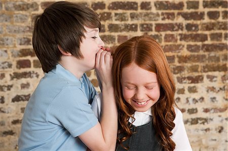 Boy whispering to girl Foto de stock - Sin royalties Premium, Código: 614-05818945