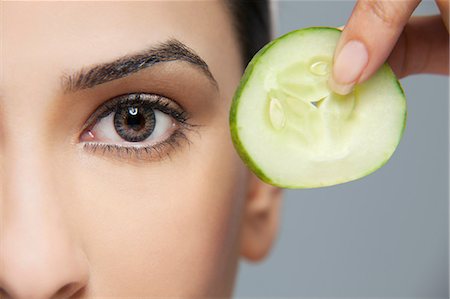 Woman with a cucumber next to her eye Foto de stock - Sin royalties Premium, Código: 614-05955231