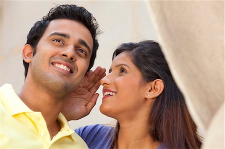 romantic young couple - Woman whispering in a mans ear Foto de stock - Sin royalties Premium, Código: 614-05955308