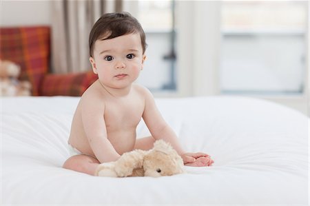 Portrait of a baby boy sitting on bed Stock Photo - Premium Royalty-Free, Code: 614-05955621