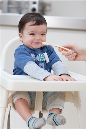 simsearch:614-05955677,k - Adult feeding baby boy in high chair Foto de stock - Sin royalties Premium, Código: 614-05955669