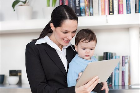 Femme d'affaires maman et son bébé regardant tablette numérique Photographie de stock - Premium Libres de Droits, Code: 614-05955679