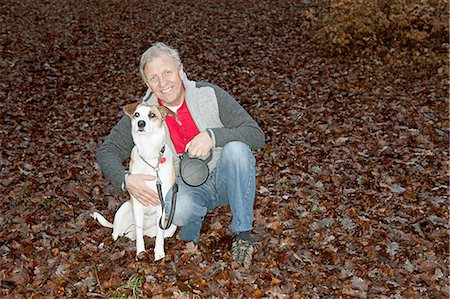 Portrait of senior man with dog in forest Stock Photo - Premium Royalty-Free, Code: 614-06002133