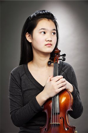 Portrait of young Asian teenage girl holding violin Stock Photo - Premium Royalty-Free, Code: 614-06002196