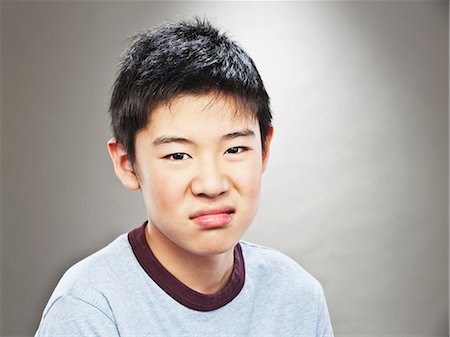 portrait of a young boy - Portrait of grimacing young Asian teenage boy Stock Photo - Premium Royalty-Free, Code: 614-06002204