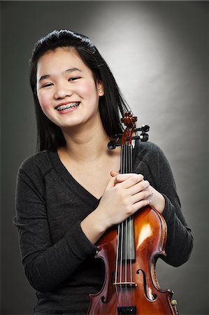 Portrait d'une jeune adolescente asiatique holding violon, souriant Photographie de stock - Premium Libres de Droits, Code: 614-06002213