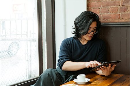 demitasse - Young man using digital tablet in cafe Foto de stock - Sin royalties Premium, Código: 614-06002320