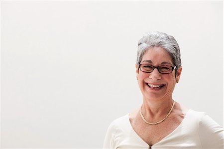 Portrait of mature woman smiling, studio shot Foto de stock - Sin royalties Premium, Código: 614-06002374