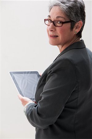 smart woman eyeglasses one person - Mature businesswoman using digital tablet, studio shot Stock Photo - Premium Royalty-Free, Code: 614-06002390