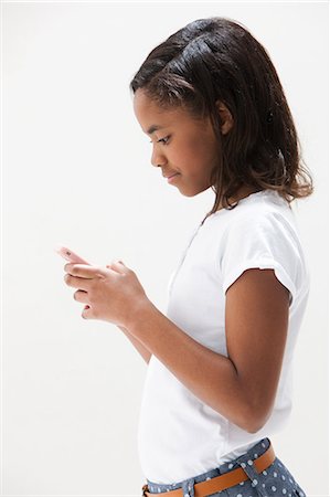 stand (structure for holding objects) - African American girl using cellphone, studio shot Foto de stock - Sin royalties Premium, Código: 614-06002410