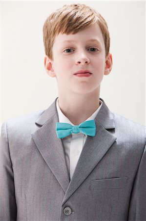 portrait of a young boy - Boy wearing grey suit and bow tie, studio shot Stock Photo - Premium Royalty-Free, Code: 614-06002425