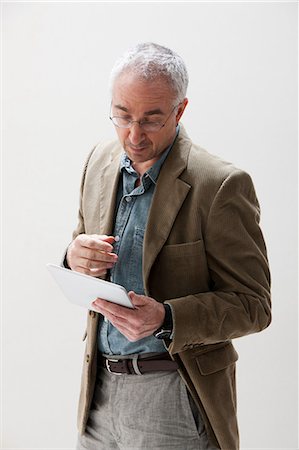 eyeglasses white background - Mature man looking at digital tablet, studio shot Stock Photo - Premium Royalty-Free, Code: 614-06002432