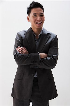 Jeune homme d'affaires asiatique, souriant, studio shot Photographie de stock - Premium Libres de Droits, Code: 614-06002453