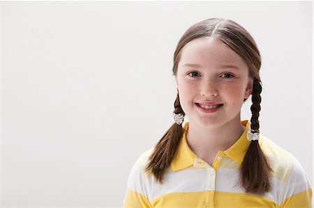 Portrait of girl smiling, studio shot Fotografie stock - Premium Royalty-Free, Codice: 614-06002462