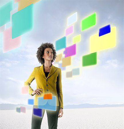 futuristic technology ideas - Businesswoman looking at holographic screens in desert Stock Photo - Premium Royalty-Free, Code: 614-06044033