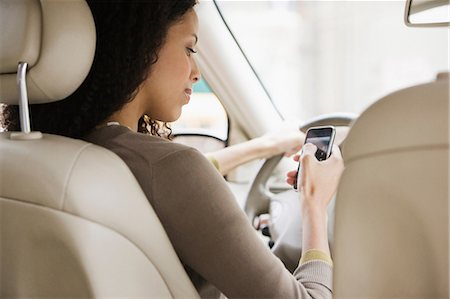 dirigir - Young woman text messaging on cellphone from car Foto de stock - Sin royalties Premium, Código: 614-06044348