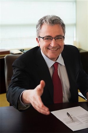 Mature businessman shaking hands at job interview Stock Photo - Premium Royalty-Free, Code: 614-06044366