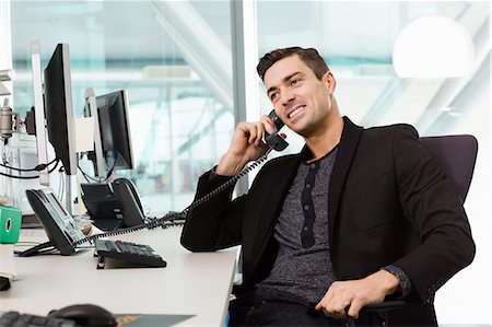 Young man on telephone in IT office Foto de stock - Sin royalties Premium, Código: 614-06044532