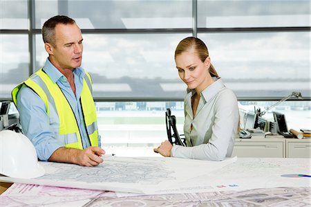 sitting at desk sideview - Engineer with architect looking at blueprints in office Stock Photo - Premium Royalty-Free, Code: 614-06044561