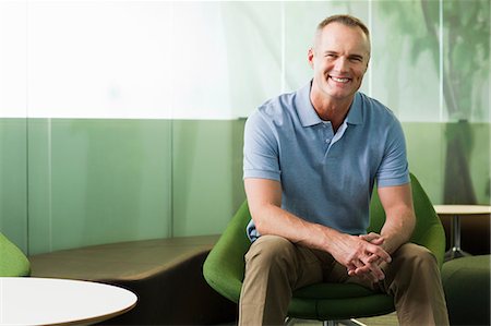 Portrait of mature man sitting in green chair in office Stock Photo - Premium Royalty-Free, Code: 614-06044596