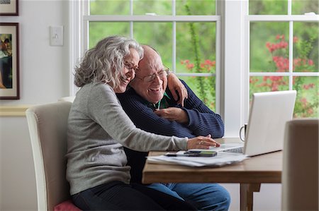 side view of senior with computer - Senior couple using laptop at home, laughing Stock Photo - Premium Royalty-Free, Code: 614-06044610