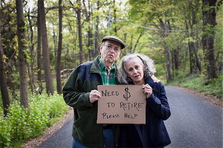 exhausted man on the road - Senior couple holding sign in forest, portrait Stock Photo - Premium Royalty-Free, Code: 614-06044635