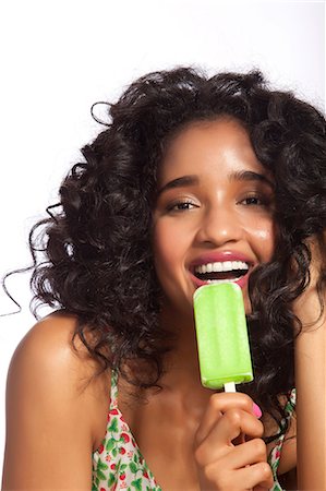 excited african american person - Young woman eating green popsicle, portrait Foto de stock - Sin royalties Premium, Código: 614-06044682