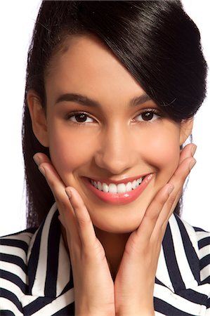 Young woman in striped top smiling against white background Stock Photo - Premium Royalty-Free, Code: 614-06044702