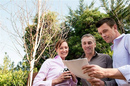 senior businessman outdoors - Three businesspeople with document Stock Photo - Premium Royalty-Free, Code: 614-06043646