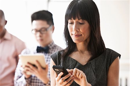 diversity and cellphone - Businesswoman using handheld computer Stock Photo - Premium Royalty-Free, Code: 614-06043795