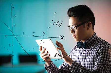 smart - Young man using digital tablet with diagram on window Stock Photo - Premium Royalty-Free, Code: 614-06043808