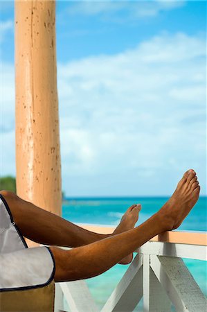 paraíso terrenal - Man on vacation with legs resting on veranda rail Foto de stock - Sin royalties Premium, Código: 614-06043822