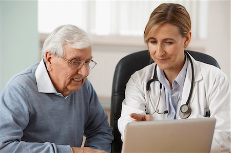 Doctor and senior man looking at laptop Stock Photo - Premium Royalty-Free, Code: 614-06043850