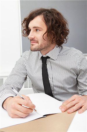 Office worker writing in notebook Stock Photo - Premium Royalty-Free, Code: 614-06043970