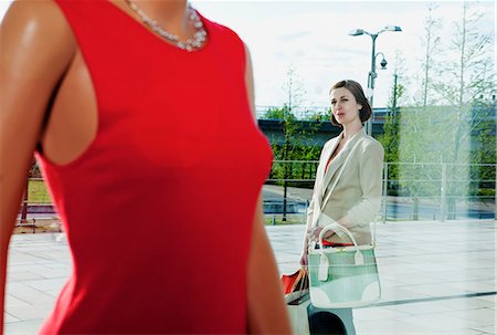 Woman looking at dress on mannequin in shop window Foto de stock - Sin royalties Premium, Código: 614-06116021