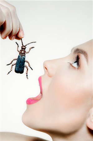 Young woman eating plastic beetle Foto de stock - Sin royalties Premium, Código: 614-06116198