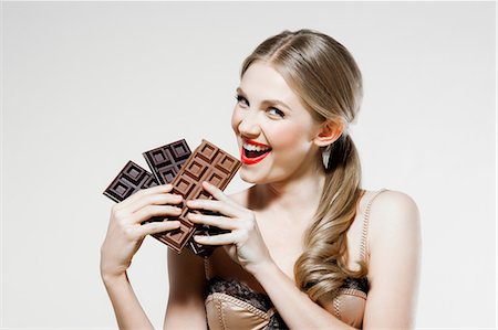 eating indulgent chocolate - Young woman holding chocolate Stock Photo - Premium Royalty-Free, Code: 614-06116193