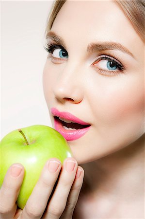 portrait of woman with fruit on head - Jeune femme eating apple Photographie de stock - Premium Libres de Droits, Code: 614-06116215